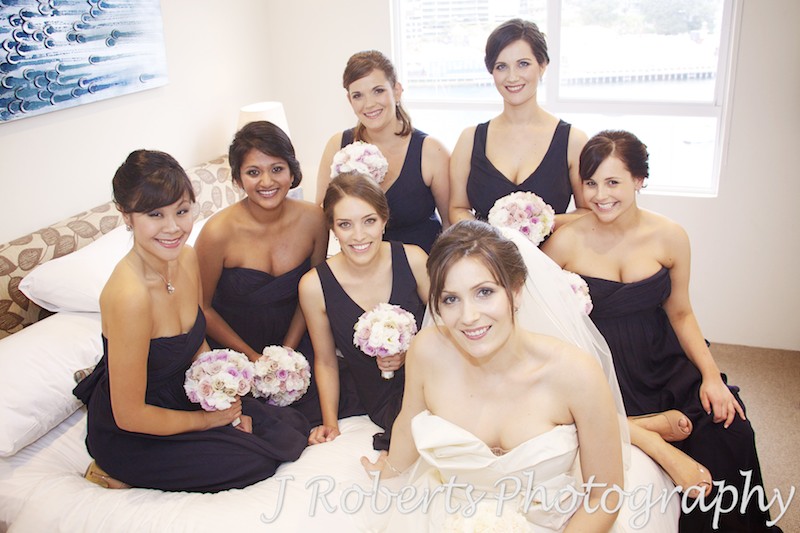 Bride sitting on bed with 6 bridesmaids - wedding photography sydney